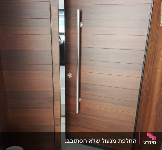 דלת כניסה מעוצבת בחיפוי עץ עם ידית משיכה מנירוסטה וצילינדר